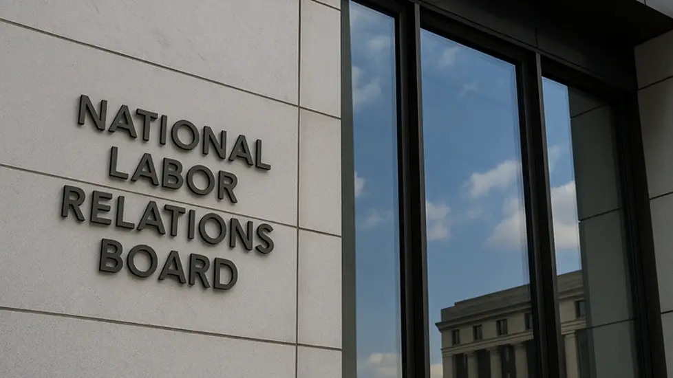 Exterior of the National Labor Relations Board headquarters building, showing the agency’s name mounted on a modern stone facade beside large reflective windows.