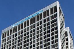 Kaiser Permanente headquarters building with the organization’s logo displayed at the top against a blue sky.