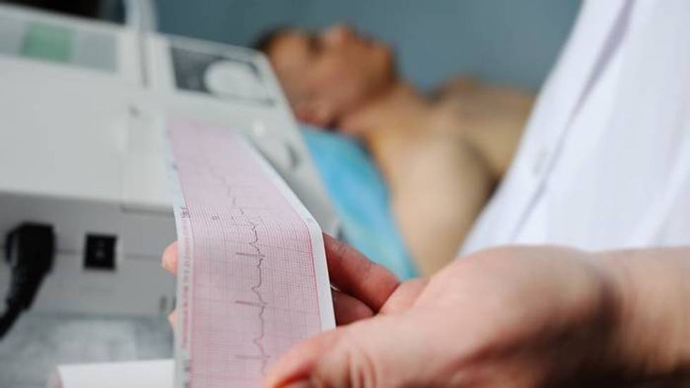 Healthcare professional reading EKG information on patient