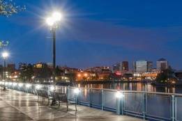 Wilmington skyline at night on a boardwalk with lamps and benches