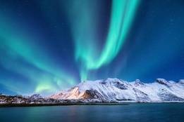 Aurora borealis over mountains and the water in Alaska