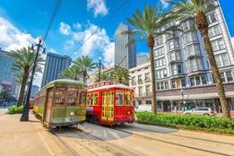 Street cars going down the street in sunny New Orleans