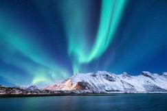 Aurora borealis over mountains and the water in Alaska