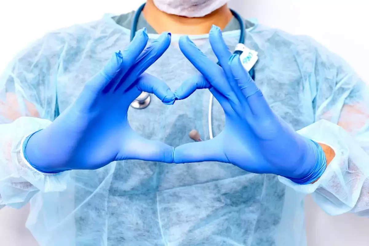 Healthcare worker wearing ppe making heart with hands