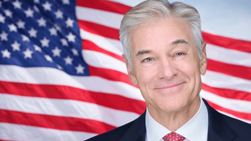 Portrait of Dr. Mehmet Oz with U.S. flag backdrop