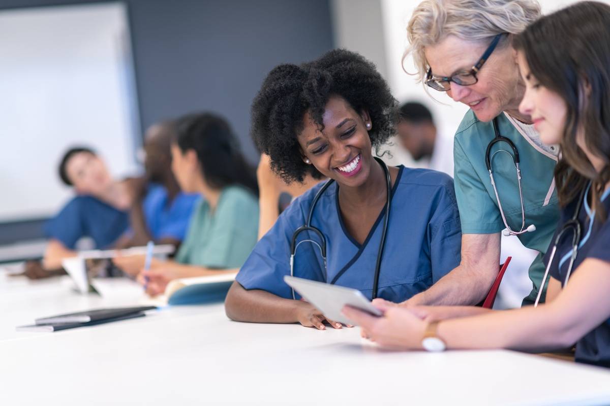 Senior female lecturer assists medical students during class