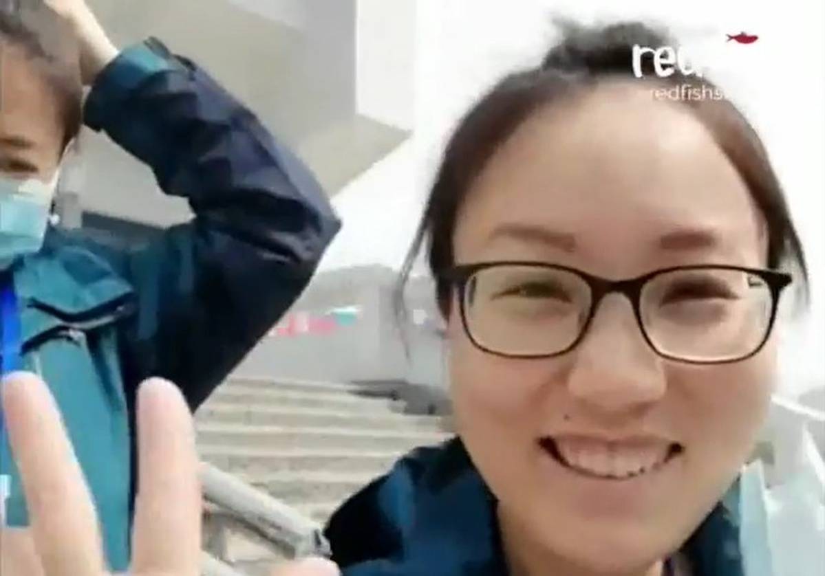 Smiling chinese nurse taking off surgical mask