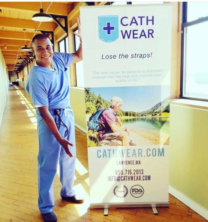 Nurse modeling next to cathwear banner in hallway